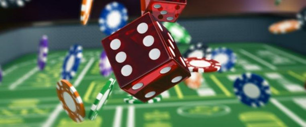 tärning kastas på casinobonrd. spelmarker i bakgrunden